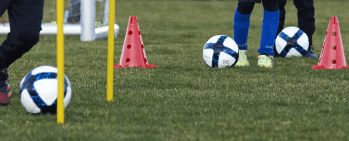 Mehrere Ballarten auf einem Sportplatz f&uuml;r Training und Freizeit