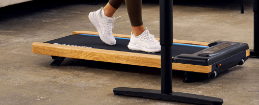 Fitnessbegeisterte Person trainiert mit einem Walking Pad im modernen Wohnraum