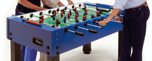 Kickertisch online kaufen – Freizeitspaß für alle Altersgruppen | im Kübler Sport Onlineshop kaufen Mehrere Personen spielen gemeinsam Tischfußball an einem Kickertisch – ideal für Freizeit, Familie und Freunde