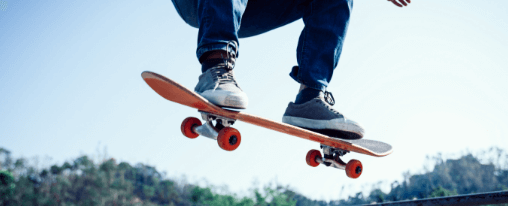 Kinder und Jugendliche beim gemeinsamen Skateboardfahren für Freizeitspiele auf dem Schulhof