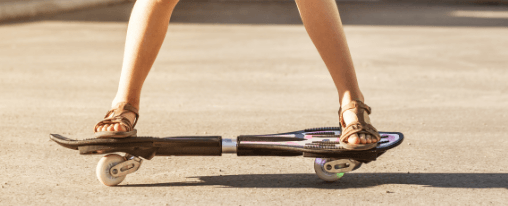 Kinder und Jugendliche beim Streetsurfing mit einem Waveboard für Freizeitspiele auf dem Asphalt