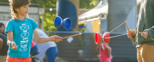 Diabolo online kaufen für Freizeitspiele im Kübler Sport Onlineshop Person spielt mit Diabolo als Freizeitspiel – Jonglage mit Handstäben und Doppelkegel im Freien