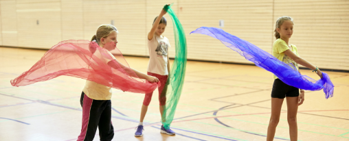 Bunte Rhythmikt&uuml;cher f&uuml;r Gymnastik&uuml;bungen in Gruppen auf einem Hallenboden