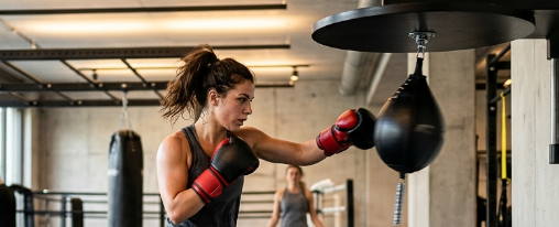 Punchingball Trainingsger&auml;t f&uuml;r Kampfsportler in moderner Trainingsumgebung mit Boxhandschuhen