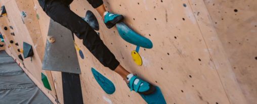 Kletterschuhe online kaufen im Kübler Sport Onlineshop Kletternde Person trägt Kletterschuhe an einer künstlichen Kletterwand