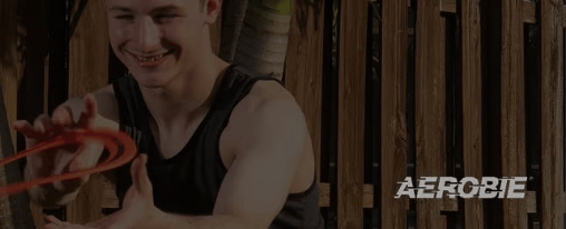 Ein Aerobie-Wurfring wird von zwei Personen bei einem Freizeitspiel im Park geworfen