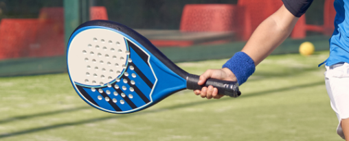 Padel Ausrüstung online kaufen bei Kübler Sport Racketsportler spielt mit Padel Ausrüstung auf einem modernen Padel Court