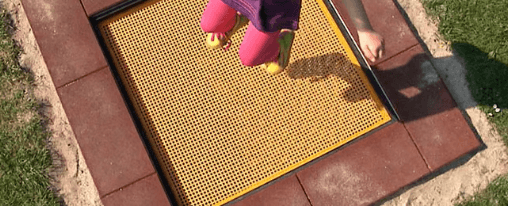 Gro&szlig;es rechteckiges Bodentrampolin mit ebenerdiger Sprungfl&auml;che und sicherer Randabdeckung als Spielplatzger&auml;t f&uuml;r Kinder