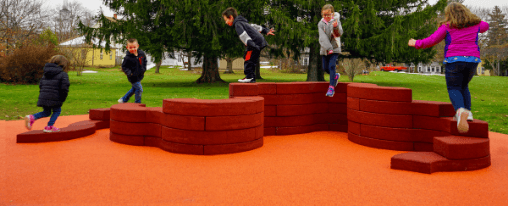 Modernes Parkmobiliar mit Sitzgruppen, Abfallbeh&auml;ltern und B&auml;nken auf einem Spielplatz