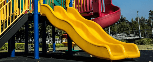 Rutschen Spielplatz online kaufen im Kübler Sport Onlineshop Kinder rutschen auf einer robusten Spielplatzrutsche im Außenbereich eines Spielplatzes