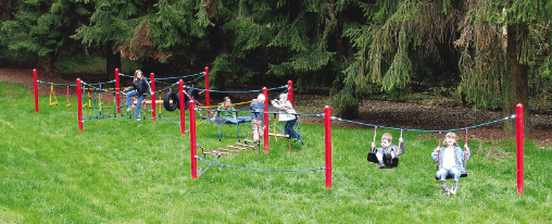 Spielende Kinder balancieren und hangeln auf einem Seilparcour auf einem modernen Spielplatz