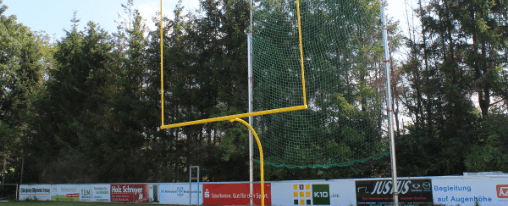 American Football Tor auf einem Spielfeld für Teamsport, mit Standpfosten, Querlatte und Bodenhülse, bereit für Training und Wettkampf