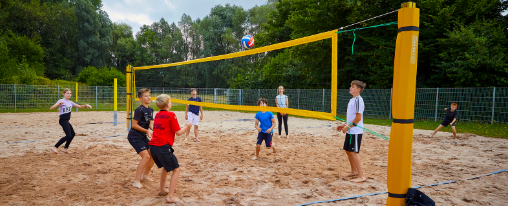 Moderne Beachvolleyballanlage mit Sandfeld, Netz und Spielfeldmarkierungen für professionellen Teamsport