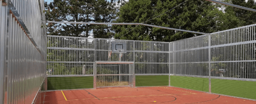 Soccer Court von Kübler Sport mit Metallgelände und rotem Platz