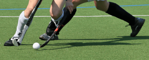 Hockeyausrüstung online kaufen im Kübler Sport Hockeyshop kaufen Hockeyspieler in Teamsport-Ausrüstung auf dem Spielfeld – große Hockeyshop Auswahl für Mannschaften