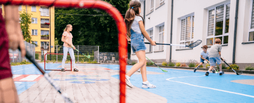 Streethockey Ausrüstung für den Teamsport bei Kübler Sport online kaufen Streethockey Team beim Spiel auf dem Spielfeld mit kompletter Ausrüstung