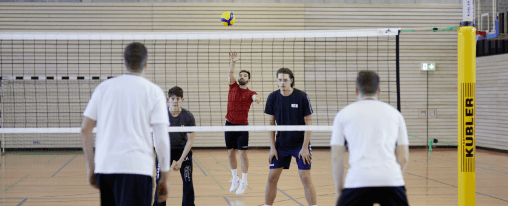 Volleyballteams spiele gegeneinander über ein Volleyballnetz