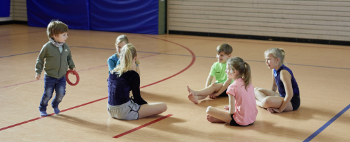 Mehrere Personen sitzen gemeinsam im Kreis und spielen Gruppenspiele zur F&ouml;rderung sozialer Kompetenzen im therapeutischen Setting