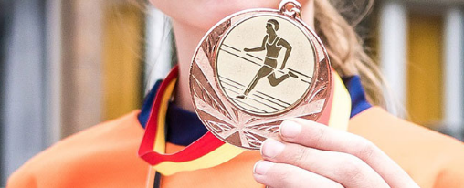 Medaillen online kaufen: Hochwertige Sportauszeichnungen für den Vereinsbedarf im Kübler Sport Onlineshop Verschiedene Medaillen als Auszeichnungen für Vereinswettkämpfe und Siegerehrungen, präsentiert auf einem Tisch