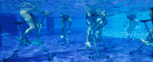 Wassersportler trainieren mit einem aquabike im Schwimmbecken