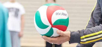 Ein Volleyball wird bereit zum Aufschlag von einem Spieler gehalten