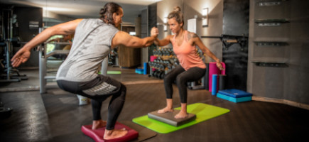 Zwei Athleten führen auf AIREX Matten und Balance Pads Gleichgewichtsübungen durch