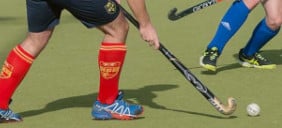 Zwei Hockeyspieler mit Hockeyball auf einem Spielfeld