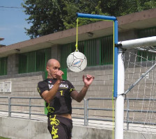 Spieler trainiert an einem Kopfballpendel welches an einem Fußballtor befestigt ist