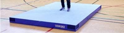 Blaue Kübler Sport Niedersprungmatte in einer Turnhalle