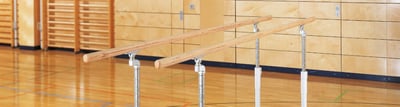 Turnbarren auf blauen Turnmatten in einer Sporthalle