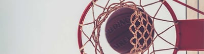 Basketballkorb mit Basketball perspektivisch von unten fotografiert mit Himmel
