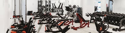 Fitnessstudio ausgestattet mit Cardiogeräten und Hanteln