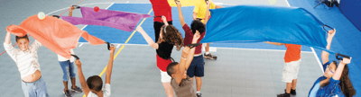 Kinder in der Sporthalle mit verschiedene und farbenfrohe Zirkusartikel als Freizeitspiele