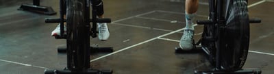 Zwei Personen auf einem Crosstrainer im Fitnessstudio