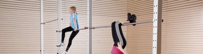Kinder turnen an einem Turnreck in der Sporthalle