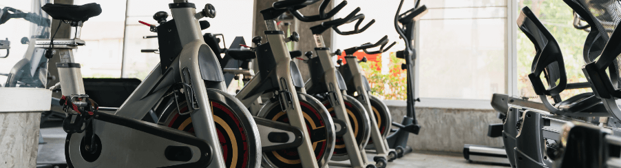 Anordnung mehrerer Indoor-Bikes nebeneinander in Reihen in einem Cardiobereiches eines Fitnessstudios
