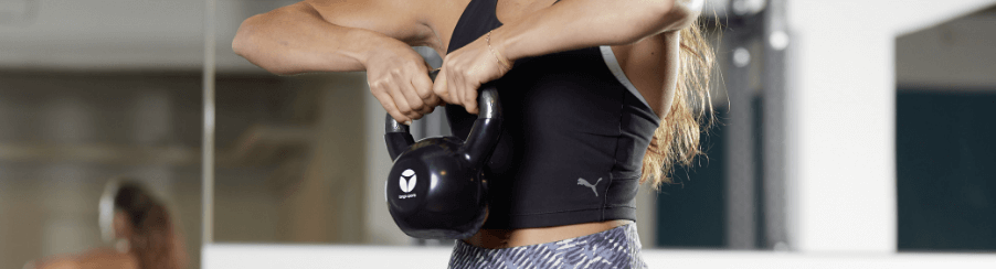 Frau führt eine Kettlebell Übung aus, ideal für Ganzkörpertraining und Core-Training.