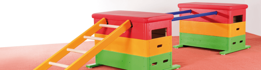 Anordnung zweier bunter Kinderturnkästen nebeneinander verbunden mit Holzelementen