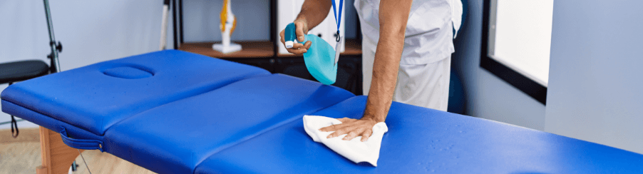 Desinfektionsmittel für Therapiebedarf, verschiedene Flaschen und Spender als Hygieneartikel auf einem Tisch in einer medizinischen Praxiseinrichtung