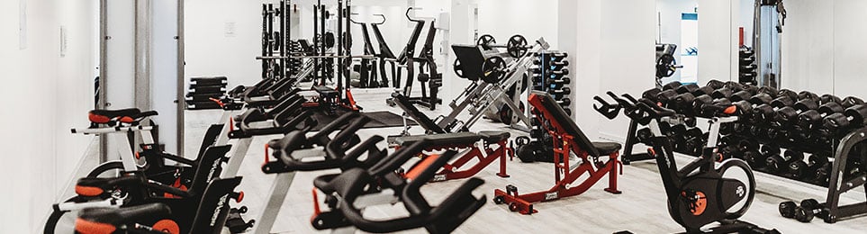 Fitnessstudio ausgestattet mit Cardiogeräten und Hanteln