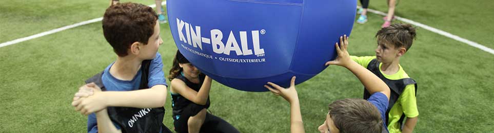 Teamsportgruppen spielen mit einem Kin-Ball in der Halle – jetzt Kin-Ball kaufen bei Kübler Sport