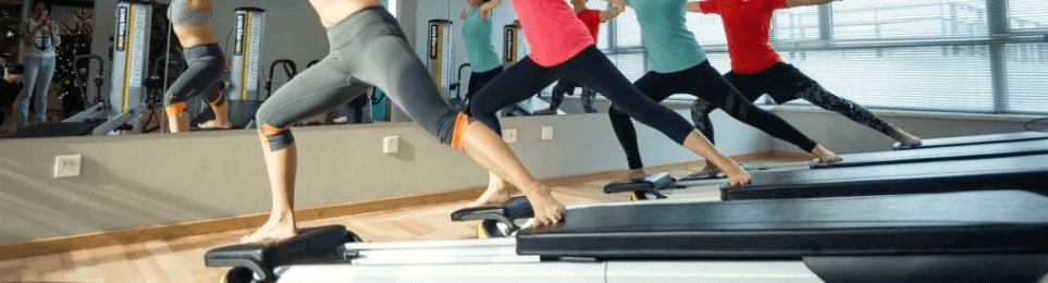Eine Gruppe im Fitnessraum auf Pilates-Geräten