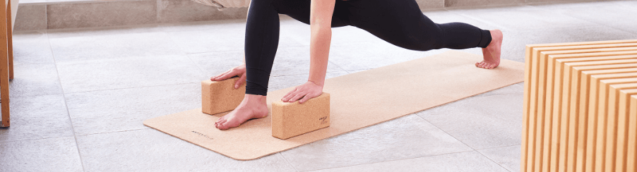Abbildung eines Yoga Block Kork, ideal für Fitnessübungen und Yogapraxis, auf einer Matte platziert.