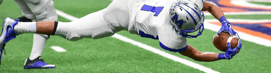 Teamsport-Equipment und Schutzausrüstung für American Football auf dem Spielfeld