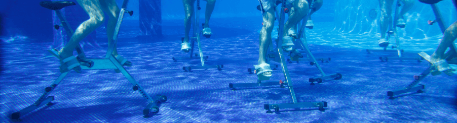 Wassersportler trainieren mit einem aquabike im Schwimmbecken
