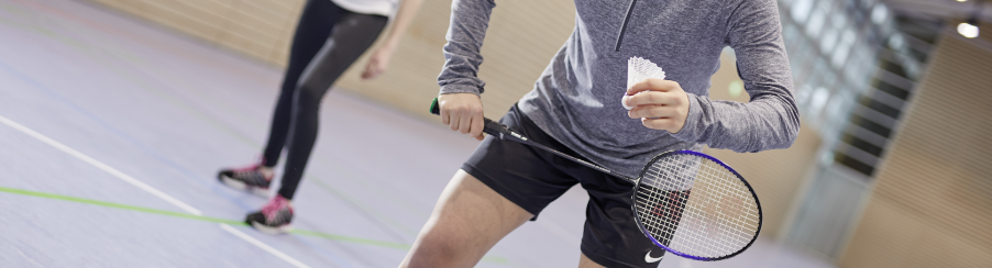 Badminton Set mit mehreren Badmintonschlägern, Federbällen und Netz für Racketsport auf einem Spielfeld