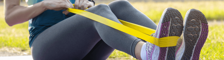 Frau trainiert mit Fitnessband