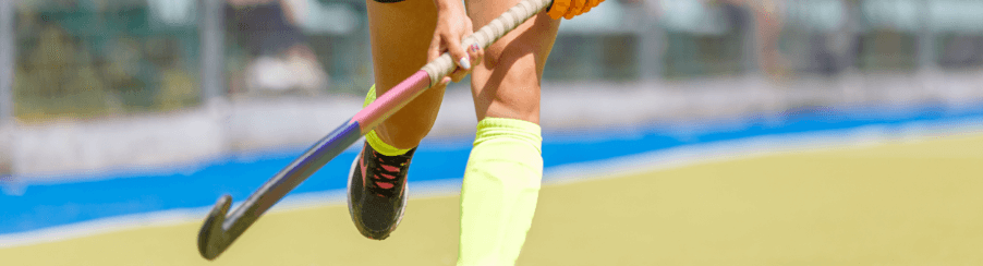 Teamsport-Spieler mit verschiedenen Hockey Schlägern auf dem Spielfeld, Auswahl an Feldhockeyschlägern für Training und Wettkampf