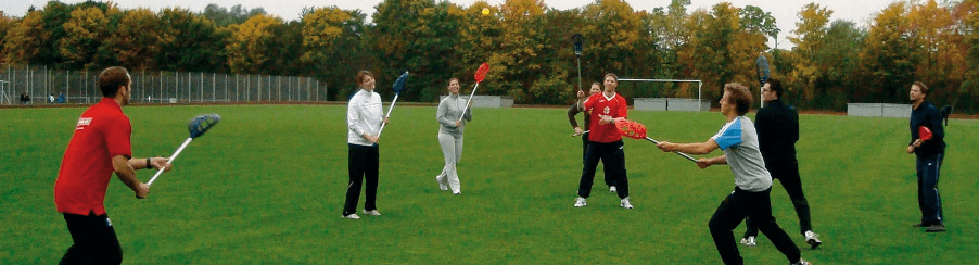 Intercrosse Ausrüstung für Teamsport mit Schlägern, Bällen und Schutzausrüstung auf einem Spielfeld