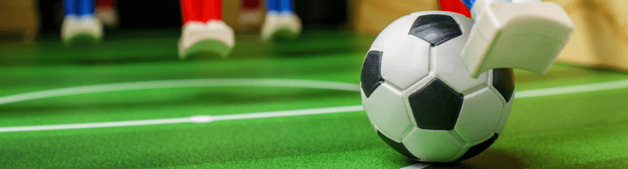 Verschiedene Kickerbälle für Freizeitspiele auf einem Tischkicker